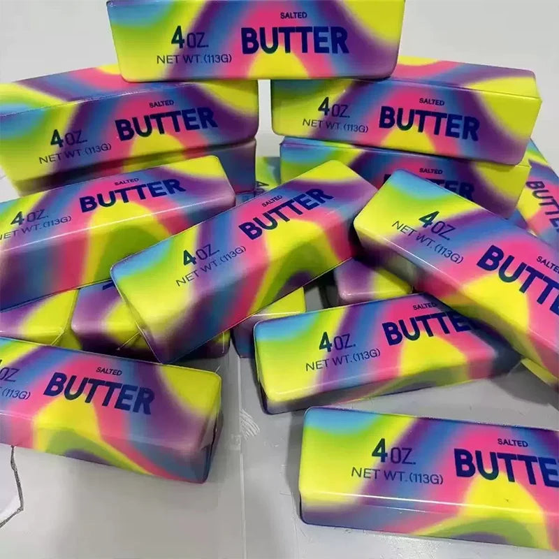 A collection of colorful butter stick fidget toys in various shades of yellow, pink, and purple.