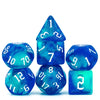 A set of seven glitter translucent blue polyhedral dice arranged on a white background.