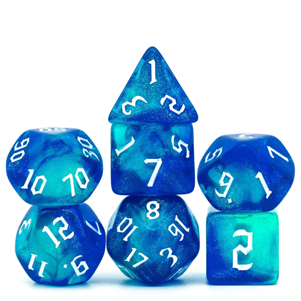 A set of seven glitter translucent blue polyhedral dice arranged on a white background.