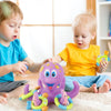 Deux tout-petits interagissent avec un jouet de bain en octopode violet et des jouets en plastique connexes.