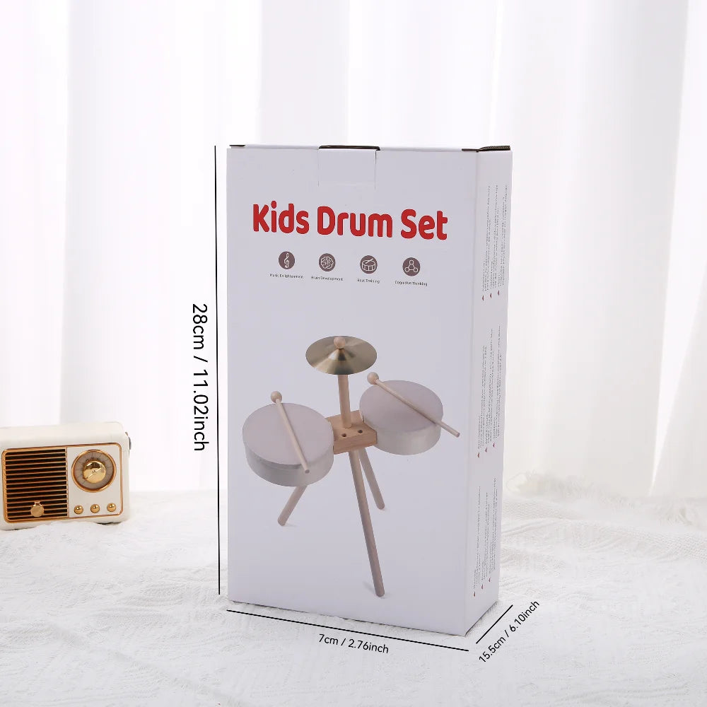 A box containing a wooden kids drum set with various drum pieces and stands.