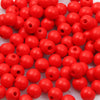 A pile of small, round, natural wooden beads in bright red color.