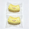 A yellow banana bear squishy stress relief toy with a butter-textured silicone finish, packaged in clear plastic.