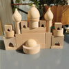 A set of wooden building blocks shaped like a castle and tower, featuring various sizes and an oval gemstone block.
