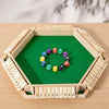 A wooden shut the box dice game with a green board and wooden dice arranged in a hexagonal frame.