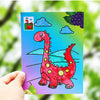 A vibrant painting kit featuring a red cartoon dinosaur on a blue background with clouds and leaves.