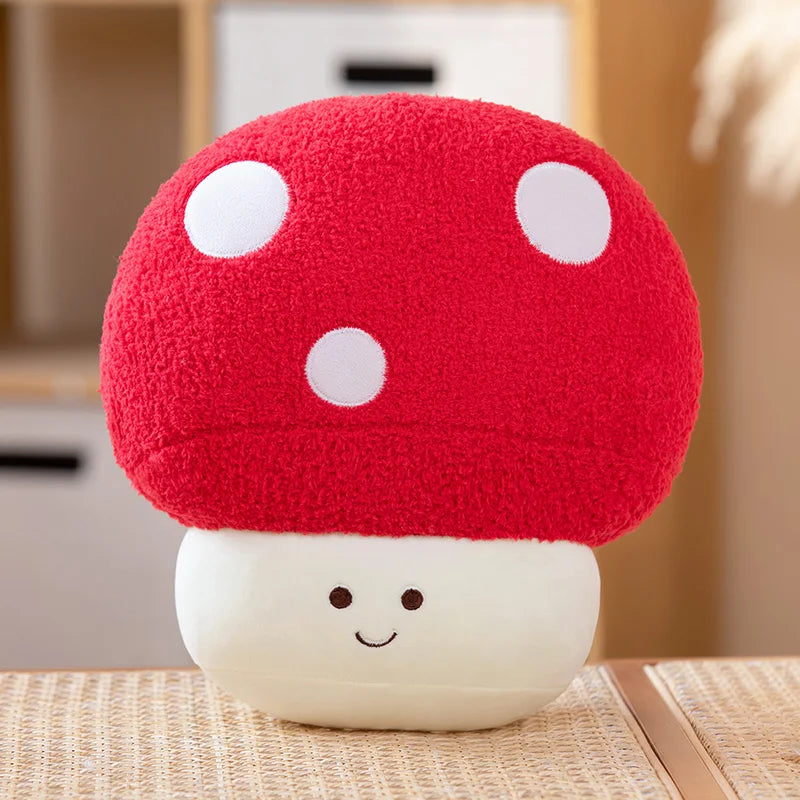 A bright red mushroom plush toy with white polka dots sits on a light wooden surface.