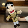 A realistic plush hand puppet with black hair, white face paint, and gold clothing is shown in a playful pose.
