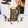 A wooden dice tower mug with a wolf emblem and various polyhedral dice resting on a white surface.