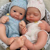 Two newborn silicone reborn dolls with knitted hats are placed in a woven basket.