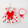 A white baby girl summer dress with red floral details and a matching white sunhat