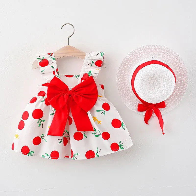 A white baby girl summer dress with red floral details and a matching white sunhat