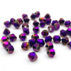 A collection of faceted bicone crystal glass beads in various shades of purple and magenta.