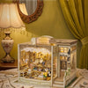 A detailed wooden miniature dollhouse kit displayed on a table with surrounding decorative elements.