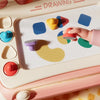 A pink magnetic drawing board with various shapes and colors used for artistic inspiration.