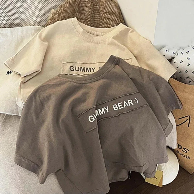 A gray short-sleeve t-shirt with the text GUMMY BEAR on the chest, displayed on a light background.