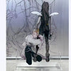 Acrylic figure of a dark-haired female character with white wings and a blonde male character in a stylized drawing backgroun