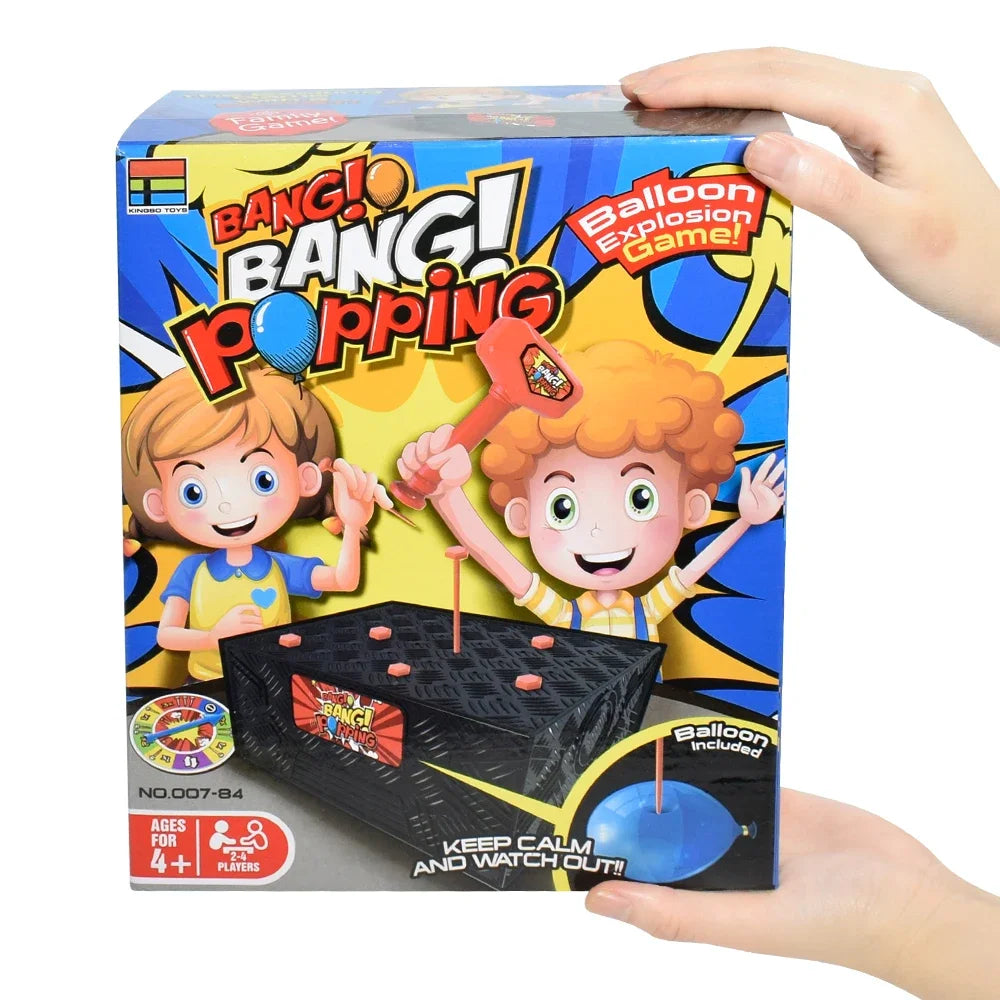 A hand holds a box of Bangi Bang Popping Balloon Explosion Game featuring two children playing.