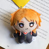 An orange-haired anime character plushie pendant charm with large eyes and a dark outfit.