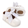 White lace-trimmed baby girl moccasin shoes with a white bow