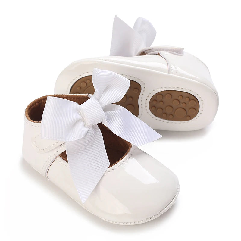 White lace-trimmed baby girl moccasin shoes with a white bow