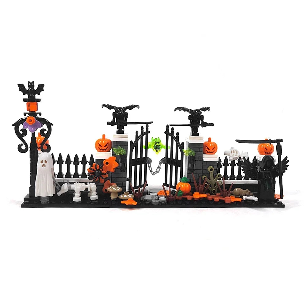 A miniature haunted house set featuring a graveyard, picket fence, spooky decorations like pumpkins and bats, and a ghostly f