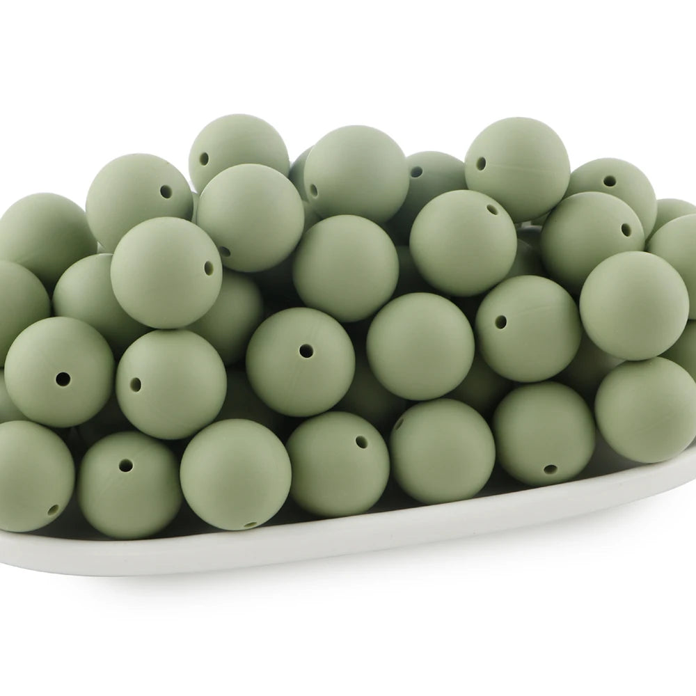 A pile of round, matte olive green silicone beads for jewelry making and DIY crafts.
