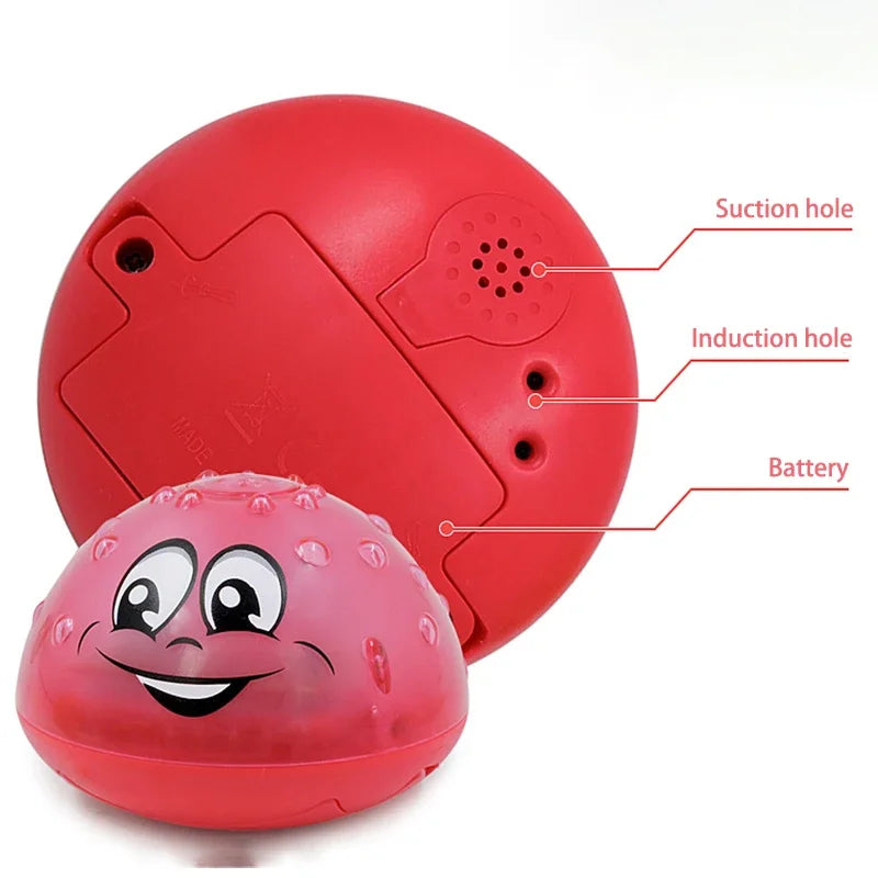 A red, spherical bath toy with suction and induction holes, featuring a smiling face and battery compartment.
