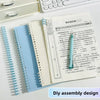 A spiral notebook with blue and white pages is shown next to a white keyboard and a pencil.
