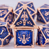A close-up of a gold metal dice set featuring skull and dragon designs on blue dice.