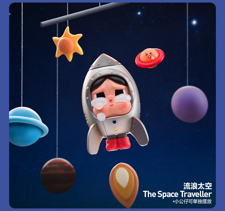 A collectible figurine of a crying astronaut floating in space with various celestial bodies like stars and planets around it