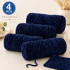 A stack of four bundles of dark blue soft chenille yarn for crochet and knitting projects.