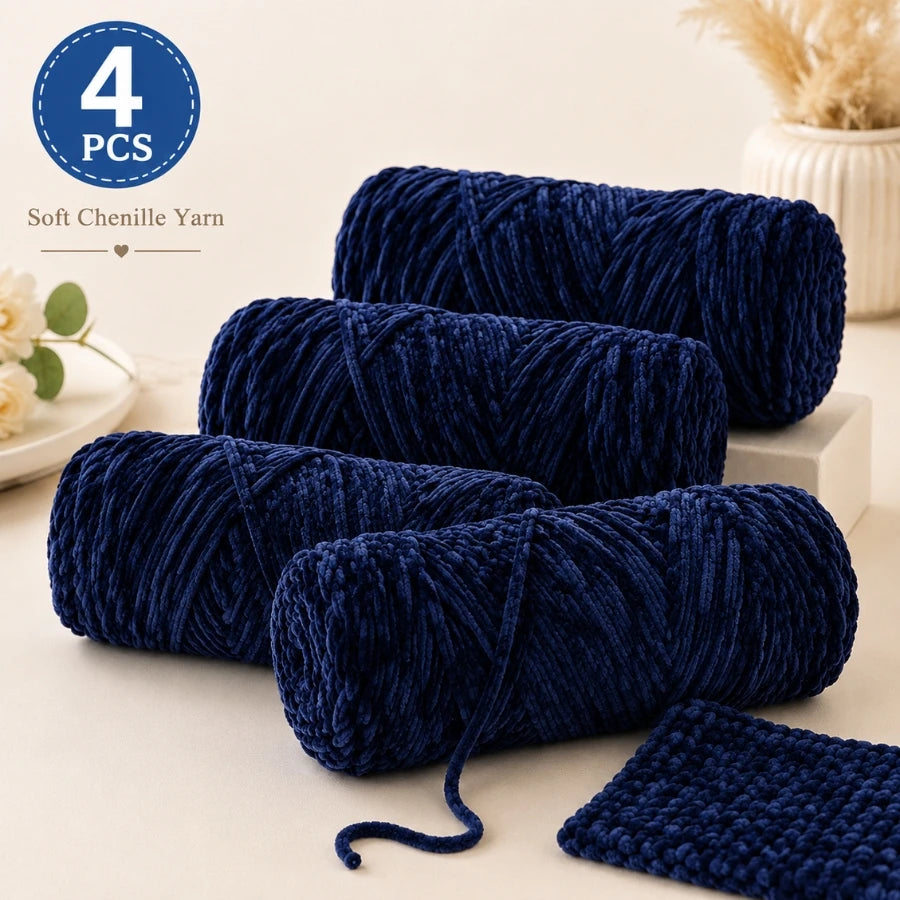A stack of four bundles of dark blue soft chenille yarn for crochet and knitting projects.