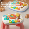 A second generation upgraded musical baby piano playmat with a light-up keyboard and hanging toys on a table.
