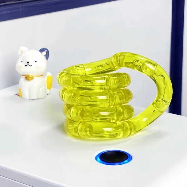 A bright yellow crystal fidget twist rope is displayed next to a white cat toy on a white surface.