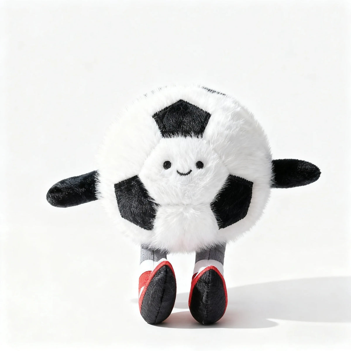 A white plush sports ball with black panels and red accents, resembling a mini basketball or soccer ball.