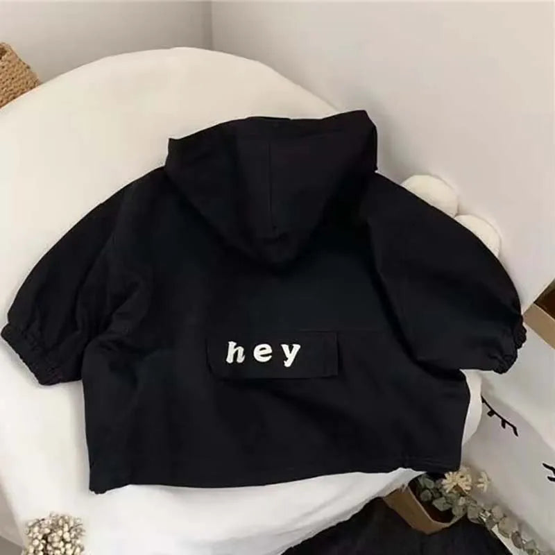 Black kids hooded letter print zip-up jacket lying on a white surface.