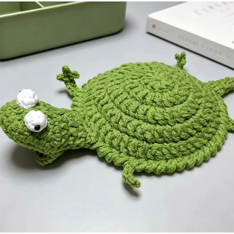 Handmade crochet lizard coaster in green with white eyes and a small white bump