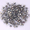 A pile of small, faceted crystal bicone glass beads for jewelry making.