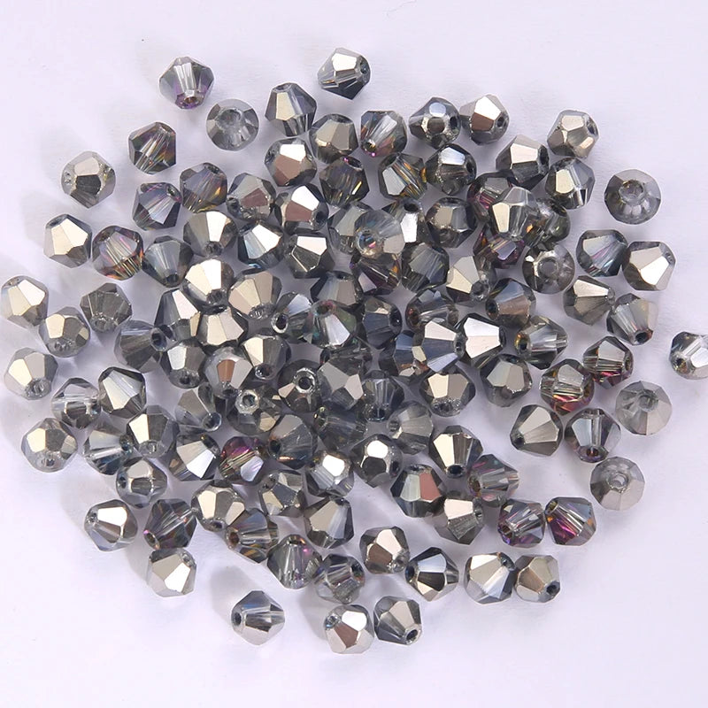 A pile of small, faceted crystal bicone glass beads for jewelry making.