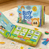 A colorful busy book for toddlers featuring reusable activity cards and seasonal themes laid out on a fluffy white surface.