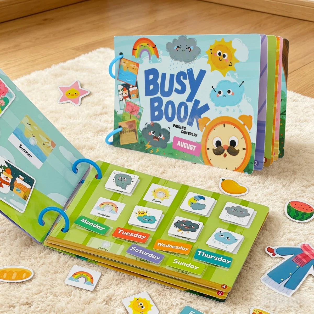 A colorful busy book for toddlers featuring reusable activity cards and seasonal themes laid out on a fluffy white surface.
