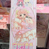 A pink and white blind box collectible figure of a girl with pink hair singing into a microphone.