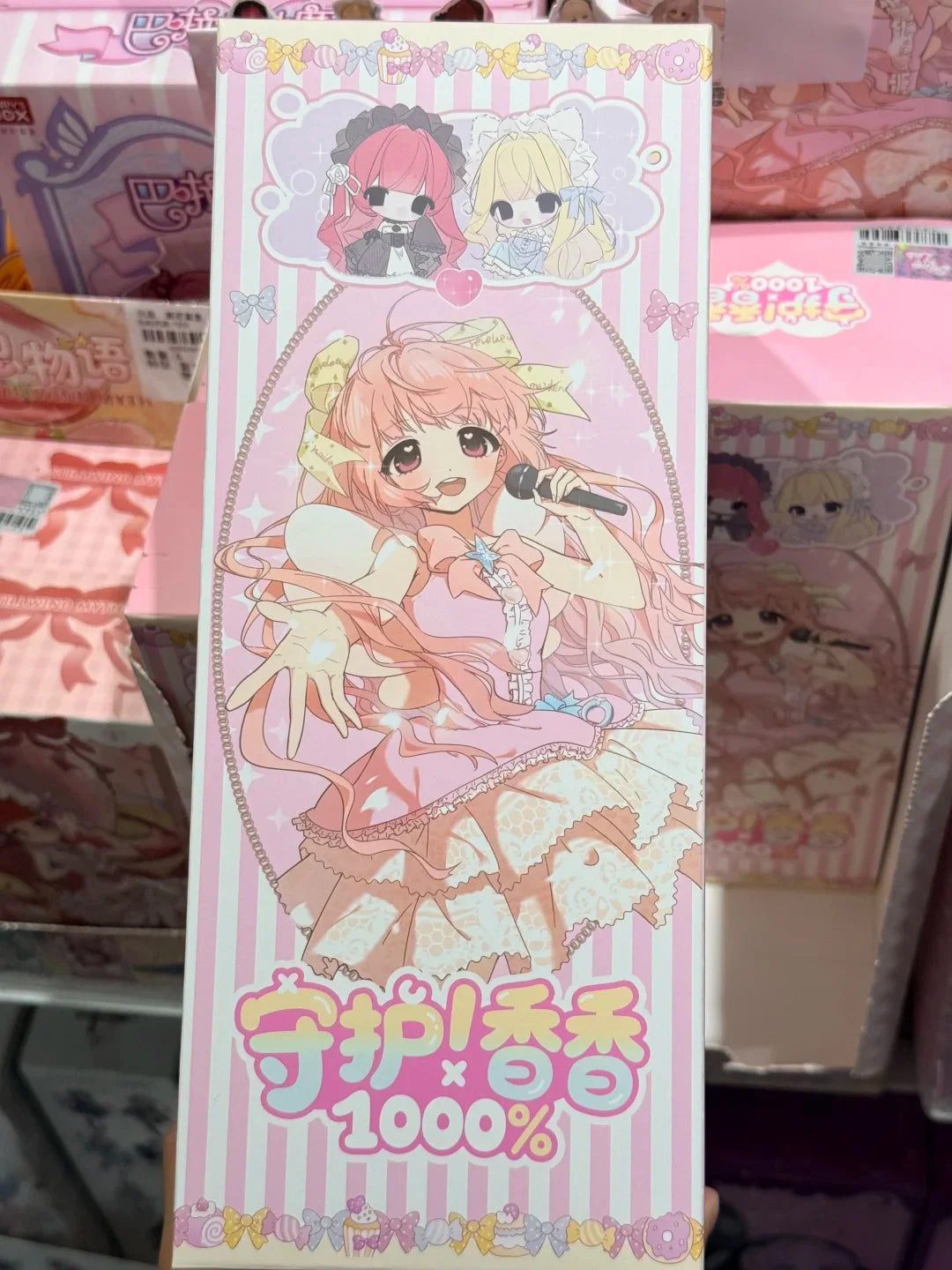 A pink and white blind box collectible figure of a girl with pink hair singing into a microphone.