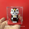 A white and black lion figurine with a gold detail is displayed inside a clear square box.