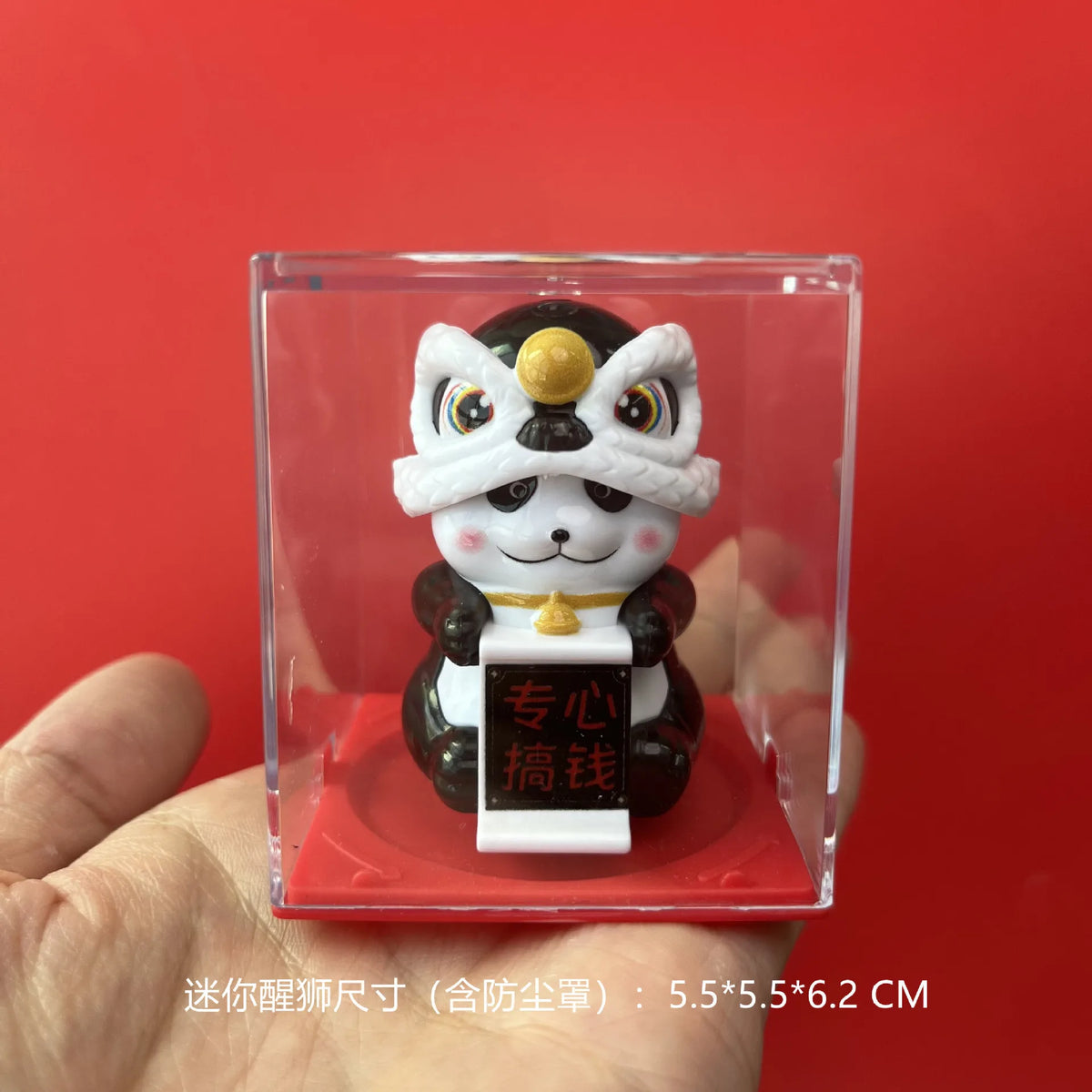 A white and black lion figurine with a gold detail is displayed inside a clear square box.