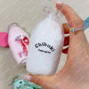 A hand is squeezing a white liquid in a glass bottle, demonstrating squishy milk bottle stress balls.