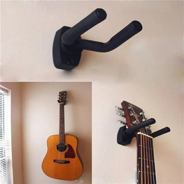 A black guitar wall mount hanger is shown mounted on a white wall next to an acoustic guitar.