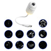 A white projector night light with an interchangeable filter, showing various starry sky patterns.
