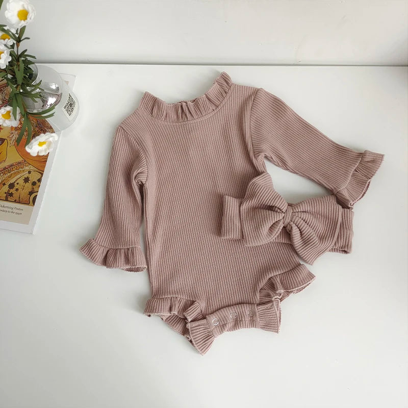 A beige ribbed long-sleeved romper for a toddler girl with ruffled details and a matching bow headband.